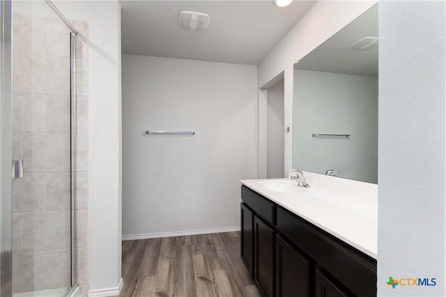 bathroom with walk in shower, vanity, and wood-type flooring