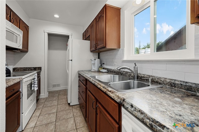 kitchen with tasteful backsplash, sink, white appliances, and light tile patterned floors