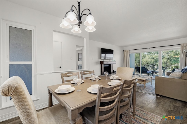 dining space with a chandelier and dark hardwood / wood-style flooring