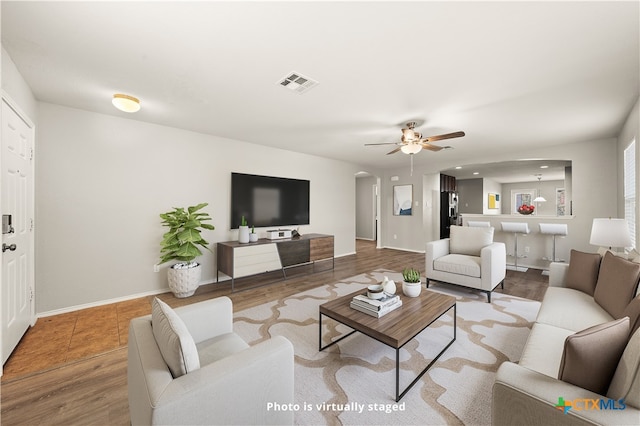 living room featuring hardwood / wood-style floors and ceiling fan