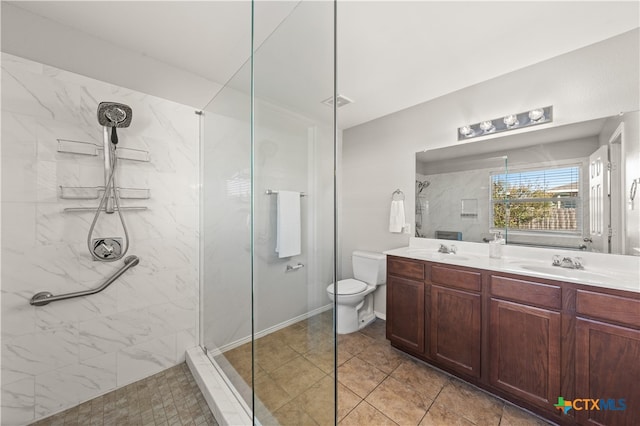 bathroom with tile patterned floors, vanity, toilet, and a tile shower