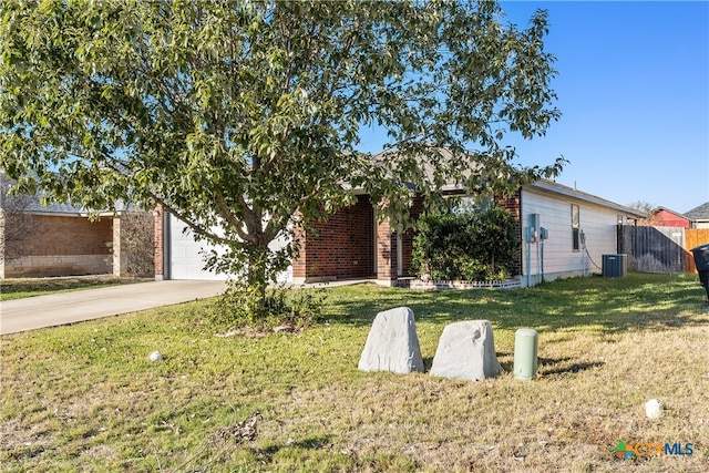 view of front facade featuring central AC, a front yard, and a garage