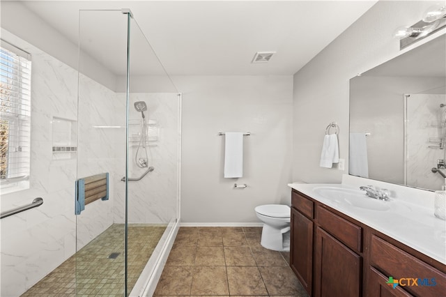 bathroom with tile patterned flooring, vanity, toilet, and an enclosed shower