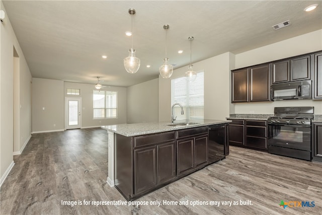 kitchen featuring dark brown cabinetry, black appliances, sink, pendant lighting, and light wood-type flooring