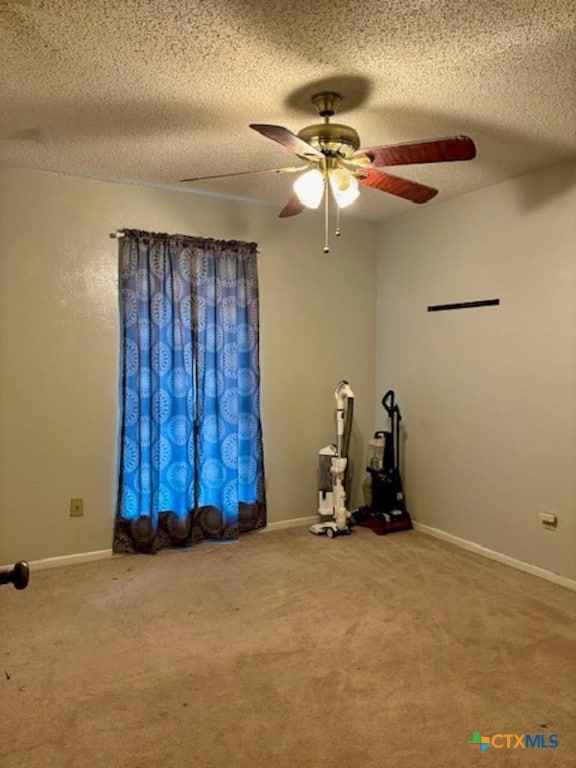 misc room featuring a textured ceiling, carpet flooring, and ceiling fan