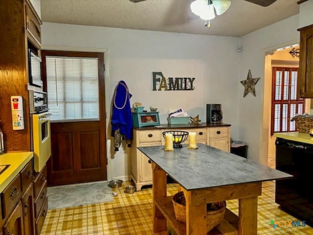 kitchen with ceiling fan, a textured ceiling, oven, and black dishwasher