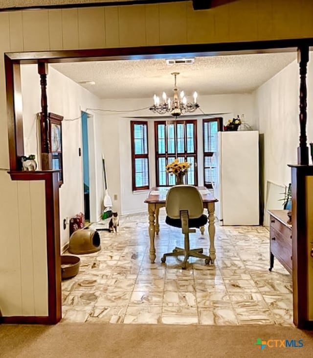 misc room with a textured ceiling, light carpet, and an inviting chandelier