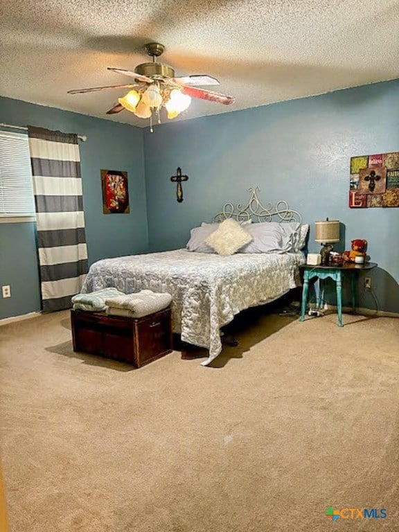 carpeted bedroom with ceiling fan and a textured ceiling