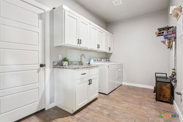 100 Metheglin Dr, Temple, TX 76502 - washroom featuring washer and clothes dryer, cabinet space, and light wood-style floors