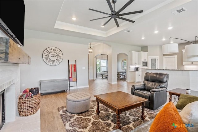 100 Metheglin Dr, Temple, TX 76502 - living room featuring arched walkways, ceiling fan, light wood-style floors, a brick fireplace, and recessed lighting