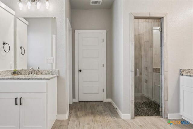 100 Metheglin Dr, Temple, TX 76502 - full bathroom featuring vanity, a shower stall, and wood finished floors