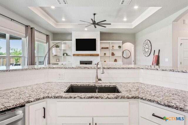 100 Metheglin Dr, Temple, TX 76502 - kitchen featuring stainless steel dishwasher, a ceiling fan, a raised ceiling, white cabinets, and ornamental molding