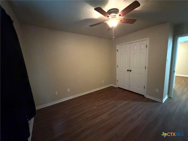 unfurnished bedroom with ceiling fan, a closet, and dark wood-type flooring