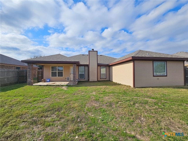 rear view of property with a yard and a patio