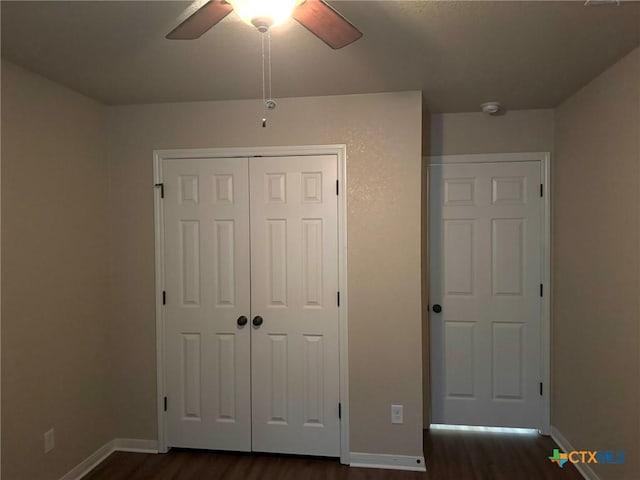 unfurnished bedroom featuring ceiling fan, dark hardwood / wood-style floors, and a closet