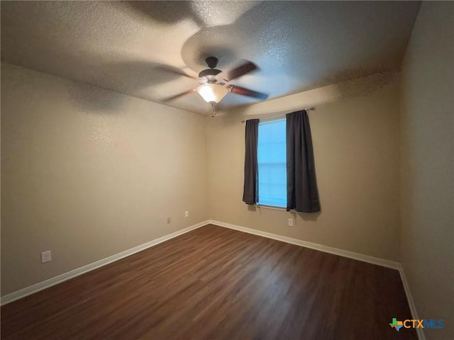 spare room featuring ceiling fan, dark wood-type flooring, and a textured ceiling