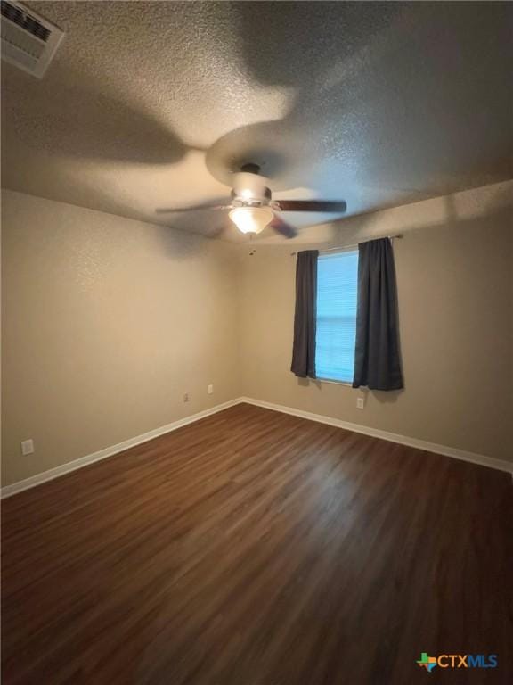 unfurnished room with a textured ceiling, dark hardwood / wood-style floors, and ceiling fan