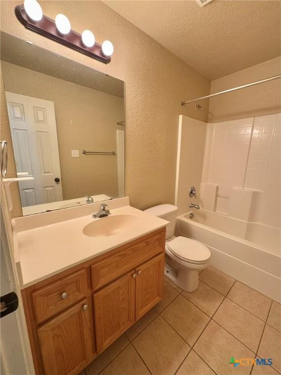 full bathroom featuring shower / bathing tub combination, vanity, tile patterned flooring, toilet, and a textured ceiling