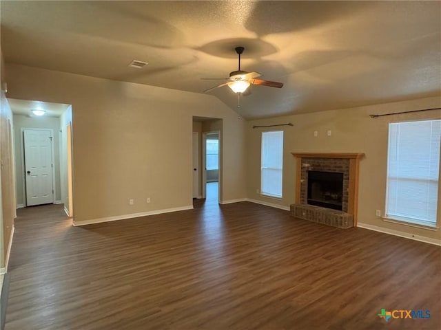 unfurnished living room featuring a brick fireplace, vaulted ceiling, ceiling fan, and dark wood-type flooring