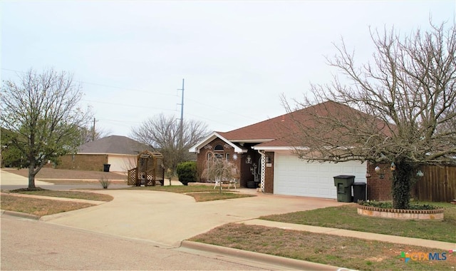 ranch-style home featuring an attached garage, concrete driveway, and brick siding