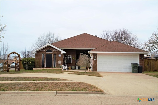 ranch-style house featuring a garage, concrete driveway, brick siding, and roof with shingles