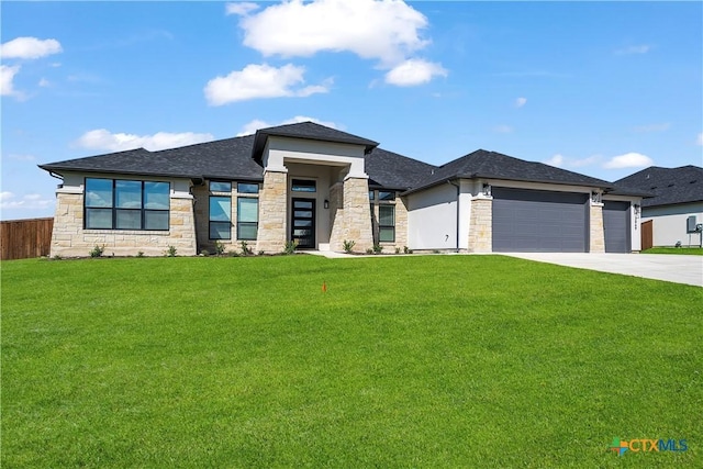 prairie-style home featuring a front lawn and a garage