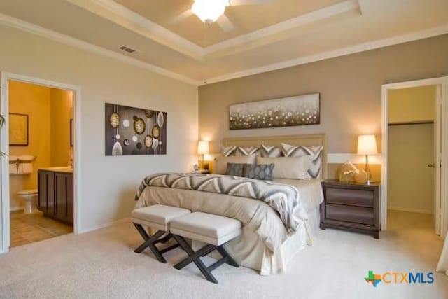1575 Laila Ln, Belton, TX 76513 - carpeted bedroom featuring a tray ceiling, ornamental molding, ensuite bathroom, and baseboards