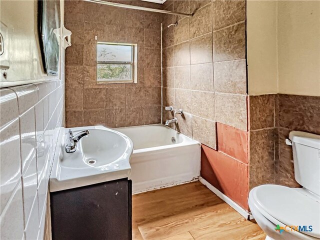 1805 E N St, Victoria, TX 77901 - full bath featuring tile walls, wood finished floors, vanity, and tub / shower combination