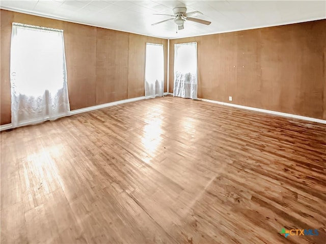 1805 E N St, Victoria, TX 77901 - spare room featuring a ceiling fan, wood finished floors, and wooden walls