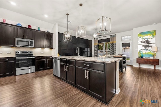 7907 Montclair Dr, Temple, TX 76502 - kitchen with stainless steel appliances, a chandelier, dark wood-type flooring, backsplash, and hanging light fixtures