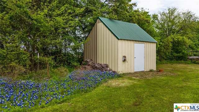 view of outbuilding featuring a lawn