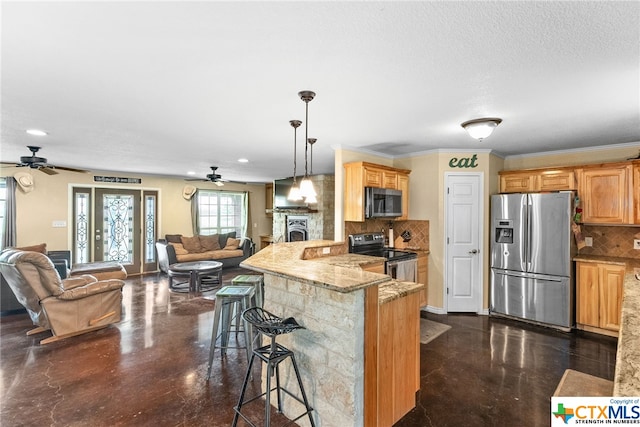 kitchen featuring a breakfast bar, kitchen peninsula, appliances with stainless steel finishes, ornamental molding, and decorative backsplash