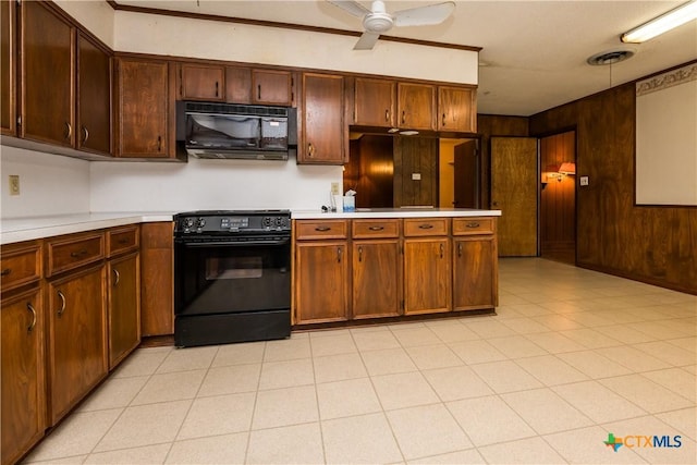 kitchen with ceiling fan, kitchen peninsula, wood walls, pendant lighting, and black appliances