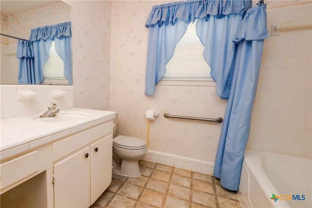 full bathroom featuring shower / bath combination with curtain, vanity, and toilet