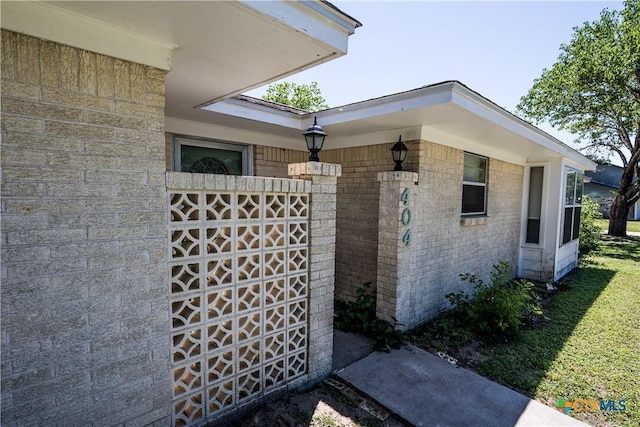 property entrance with a lawn