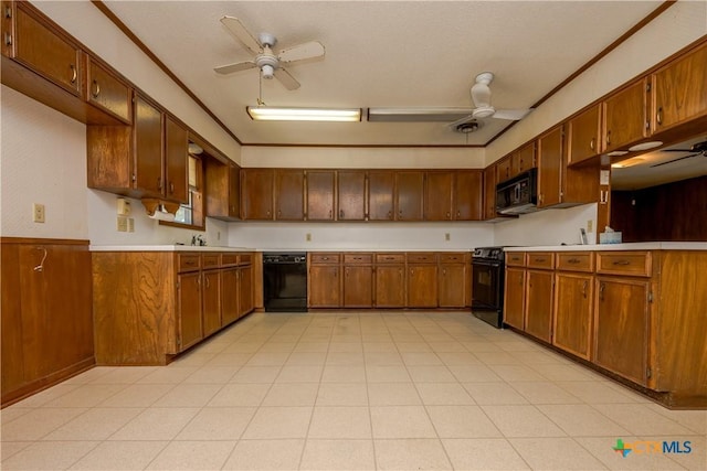 kitchen with black appliances, wood walls, sink, and crown molding