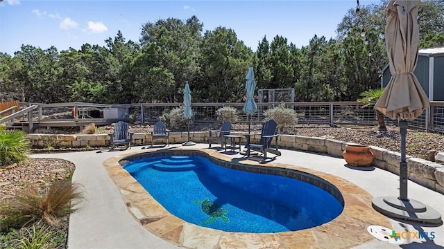 view of swimming pool featuring a patio area and fence