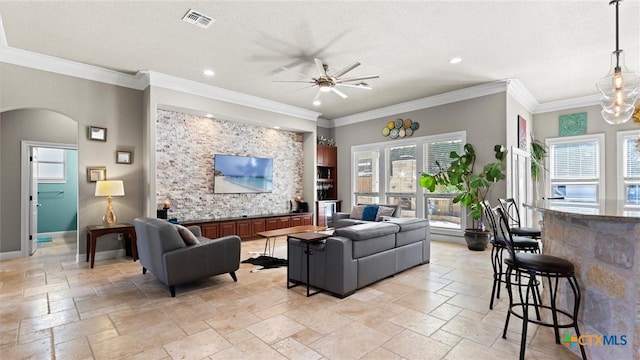 living room with baseboards, arched walkways, visible vents, and stone tile flooring