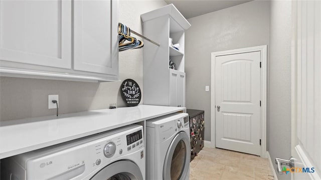 laundry area featuring stone finish flooring, cabinet space, separate washer and dryer, and baseboards