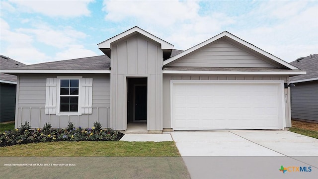 ranch-style house with board and batten siding, concrete driveway, a shingled roof, an attached garage, and a front lawn