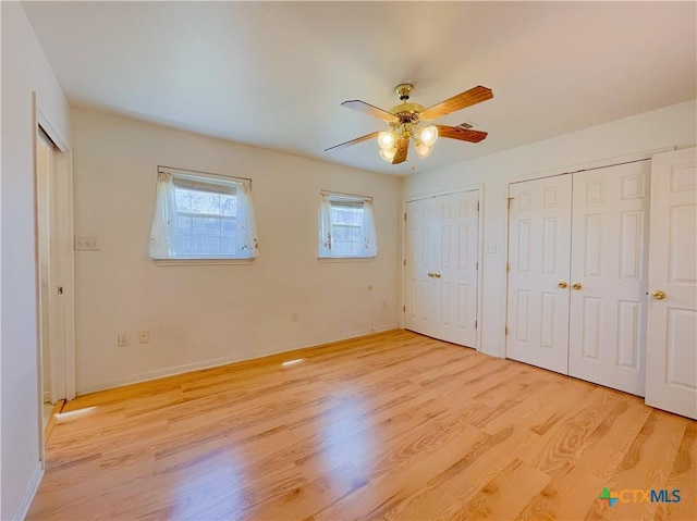 174 Fm 2808, Kempner, TX 76539 - unfurnished bedroom featuring two closets, light wood finished floors, a ceiling fan, and baseboards