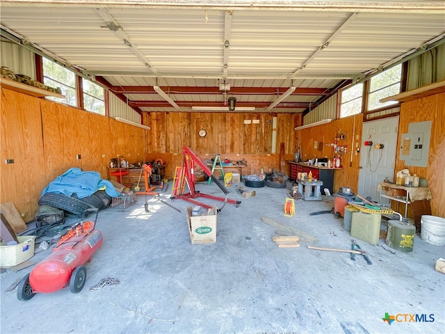 garage with electric panel and wood walls