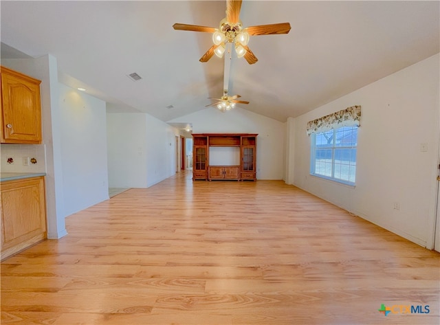 unfurnished living room featuring light wood-type flooring, ceiling fan, and vaulted ceiling