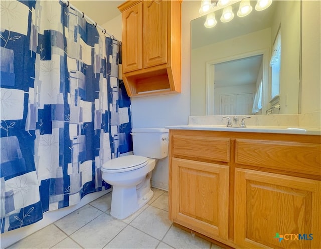 bathroom with toilet, vanity, and tile patterned floors