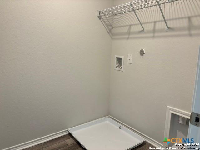2537 Windle Ln, Seguin, TX 78155 - laundry room featuring washer hookup, baseboards, and dark wood-type flooring