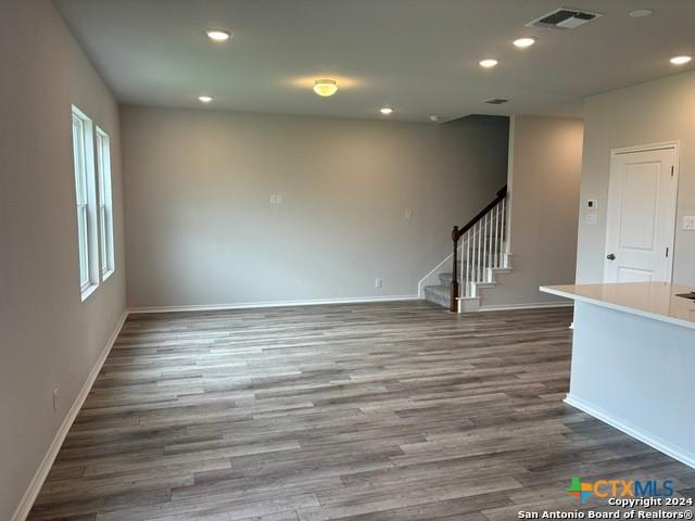 2537 Windle Ln, Seguin, TX 78155 - empty room with stairs, dark wood-style flooring, recessed lighting, and baseboards