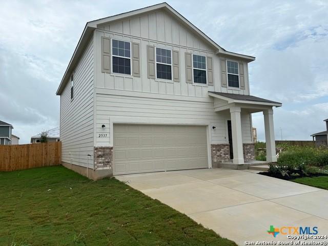 2537 Windle Ln, Seguin, TX 78155 - view of front of home featuring board and batten siding, a garage, brick siding, and driveway
