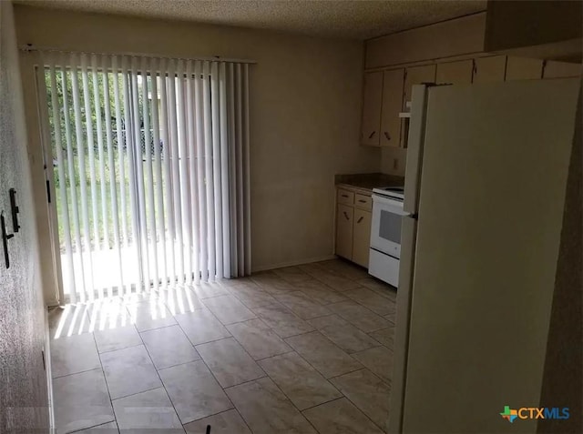 kitchen with white appliances, a textured ceiling, and light tile patterned floors