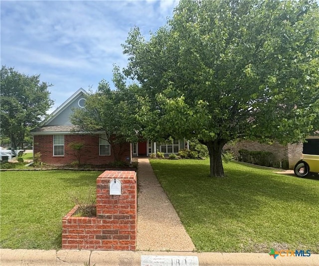 view of front of house featuring brick siding and a front yard
