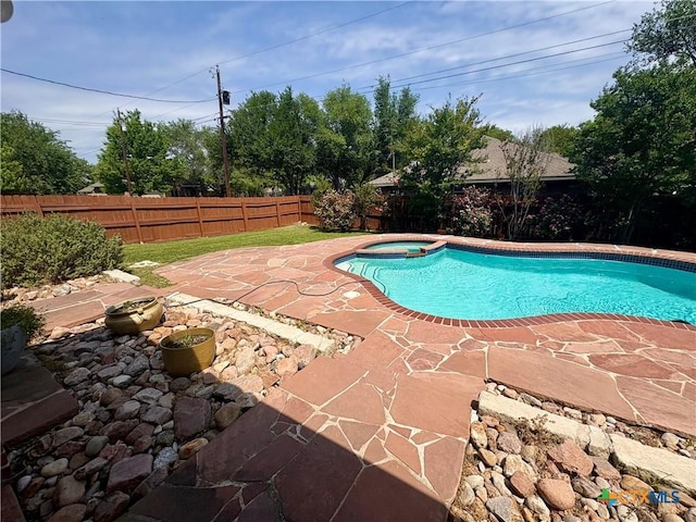 view of pool featuring a pool with connected hot tub, a fenced backyard, and a patio area